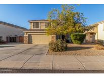 Two-story house with a tan elevation, two-car garage, and landscaped front yard at 12738 W Hollyhock Dr, Avondale, AZ 85392