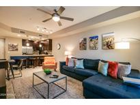 Open living room featuring sectional sofa, coffee table, and large TV at 5450 E Deer Valley Dr # 1176, Phoenix, AZ 85054