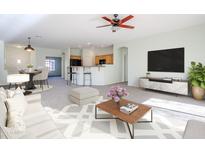 Bright living room with open floor plan, featuring a ceiling fan and access to kitchen at 7019 S Golfside Ln, Phoenix, AZ 85042