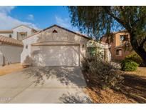 House exterior featuring a two-car garage and desert landscaping at 43842 W Elizabeth Ave, Maricopa, AZ 85138