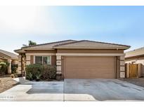 Single-story home with a two-car garage and desert landscaping at 9941 W Chipman Rd, Tolleson, AZ 85353