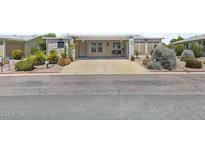 Beige manufactured home with covered porch, landscaping, and driveway at 215 N Power Rd # 361, Mesa, AZ 85205
