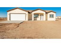 Newly constructed home with a two-car garage and desert landscaping at 35648 W Hidalgo Ave, Tonopah, AZ 85354