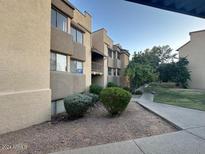 Tan stucco building exterior with walkway and landscaping at 18811 N 19Th Ave # 3025, Phoenix, AZ 85027