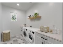 Bright laundry room with washer, dryer, and ample counter space at 943 N 97Th Way, Mesa, AZ 85207