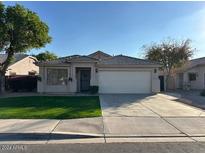 Tan house with a two-car garage and well-manicured lawn at 3279 E Woodside Way, Gilbert, AZ 85297