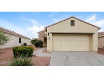 Tan house with stone accents, two-car garage, and landscaped yard at 22409 N Los Gatos Dr, Sun City West, AZ 85375