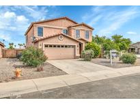 Two-story house with tan exterior, two-car garage, and landscaping at 25370 W Jackson Ave, Buckeye, AZ 85326