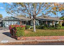 Single story home with brick facade, attached two-car garage, and landscaping at 5056 E Weldon Ave, Phoenix, AZ 85018