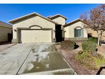 Single-story house with beige exterior, two-car garage, and landscaped front yard at 25742 W Victory W St, Buckeye, AZ 85326