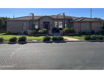 One-story house with landscaped yard, featuring a neutral color palette and a welcoming front entrance at 3331 E Indigo Cir, Mesa, AZ 85213