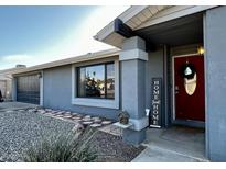 Ranch style home with gray exterior, red door, and landscaped walkway at 1443 W Morrow Dr, Phoenix, AZ 85027