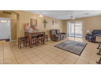 Living room with tiled floors and a large TV at 14834 W Calavar Rd, Surprise, AZ 85379