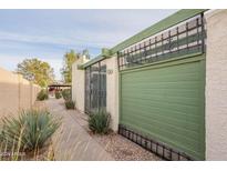View of the property's exterior, including a gated entrance and a green garage door at 524 S Allred Dr, Tempe, AZ 85288
