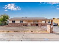 Brick ranch house with a covered porch and a well-maintained yard at 11428 N 57Th Ln, Glendale, AZ 85304