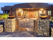 Stunning desert home with wrought iron gate and beautiful landscaping at 15405 E Cavedale Dr, Scottsdale, AZ 85262