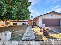 Ranch style home with mature landscaping, walkway, and attached garage at 4011 W Palo Verde Dr, Phoenix, AZ 85019