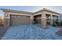 Tan house with brown garage door, stone accents, and paved driveway at 19725 E Escalante Rd, Queen Creek, AZ 85142