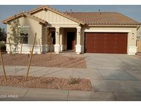 One-story home with brown garage door and desert landscaping at 21024 E Poco Calle St, Queen Creek, AZ 85142