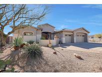 Tan house with a three-car garage and drought-tolerant landscaping at 3701 E Sat Nam Way, Cave Creek, AZ 85331