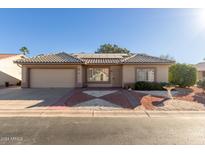 Tan house with tile roof, solar panels, and landscaped yard at 6401 S Pebble Beach Dr, Chandler, AZ 85249