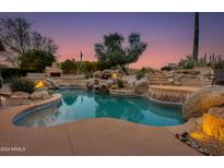 Inviting pool and spa with waterfall feature at sunset at 10542 E Skinner Dr, Scottsdale, AZ 85262