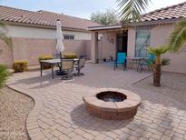 Relaxing backyard patio with fire pit and seating area, great for outdoor dining at 40160 W Mary Lou Dr, Maricopa, AZ 85138