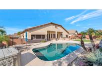 Inviting backyard oasis with a sparkling pool, spacious patio, and lush landscaping at 4633 N 127Th Dr, Litchfield Park, AZ 85340