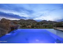 Stunning pool at dusk with mountain views and a waterfall feature at 4748 E White Dr, Paradise Valley, AZ 85253