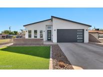 Modern single-story home with attached garage and landscaped lawn at 1421 E Weldon Ave, Phoenix, AZ 85014