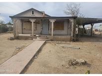 One-story house needing complete renovation. Features a covered porch and a small yard at 15420 N Jerry St, Surprise, AZ 85378