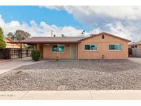 Tan single story house with carport, and rock landscaping at 2325 W Orchid Ln, Phoenix, AZ 85021