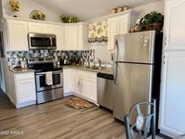 Bright kitchen featuring white cabinets, stainless steel appliances, and granite countertops at 7750 E Broadway Rd # 911, Mesa, AZ 85208