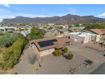 Aerial view of a single-story home with solar panels, desert landscaping, and mountain views at 10232 E Fortuna Ave, Gold Canyon, AZ 85118