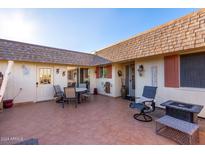 Inviting patio with seating area, fire pit, and tile flooring at 10413 W Camelot Cir, Sun City, AZ 85351