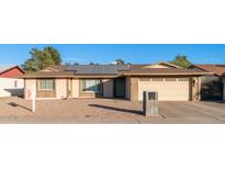 Ranch style home with solar panels and a two-car garage at 14821 N 51St Dr, Glendale, AZ 85306