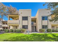 Tan two-story condo building with grassy yard and stairs at 145 N 74Th St # 108, Mesa, AZ 85207