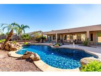 Inviting kidney-shaped pool with a waterfall feature and a large backyard at 384 W Chuckwagon Ln, San Tan Valley, AZ 85143