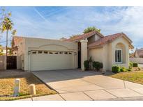 Exterior view of a single-story home with a tile roof, attached garage, and driveway at 1213 W Seascape Ct, Gilbert, AZ 85233