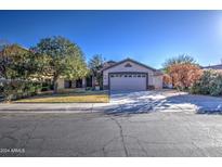 Charming single-story home with a two-car garage and landscaped front yard at 3335 E San Angelo Ave, Gilbert, AZ 85234
