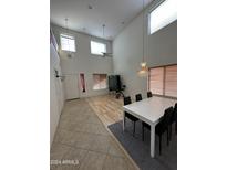 Dining room with high ceilings, wood floors, and a white dining table at 300 S 151St Ave, Goodyear, AZ 85338