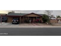 Tan house with a carport and landscaping at 3630 N 86Th Ave, Phoenix, AZ 85037