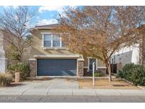 Tan two-story house with a gray garage door and landscaping at 6124 N Florence Ave, Litchfield Park, AZ 85340