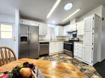 Bright kitchen featuring stainless steel appliances, white cabinetry, and tile flooring at 9333 E University Dr # Ofc, Mesa, AZ 85207