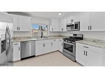 Modern kitchen featuring white shaker cabinets, granite countertops, and stainless steel appliances at 461 N Madison St, Wickenburg, AZ 85390