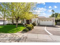 Charming two-story home with a landscaped front yard and a three-car garage at 10667 E Fanfol Ln, Scottsdale, AZ 85258