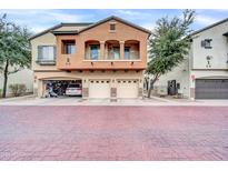 Two-story townhome with attached two-car garage and brick driveway at 2727 N Price Rd # 6, Chandler, AZ 85224