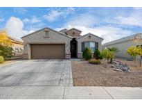 Single-story house with a brown garage door and landscaped front yard at 23793 W Ripple Rd, Buckeye, AZ 85326