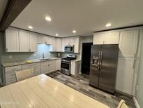 Updated kitchen with white cabinets, stainless steel appliances, and granite countertops at 745 N San Pedro Dr, Mammoth, AZ 85618