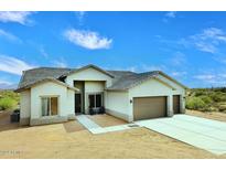 Exterior view of a single-story home with a three-car garage, desert landscaping, and a tiled roof at 36023 N 140Th St, Scottsdale, AZ 85262